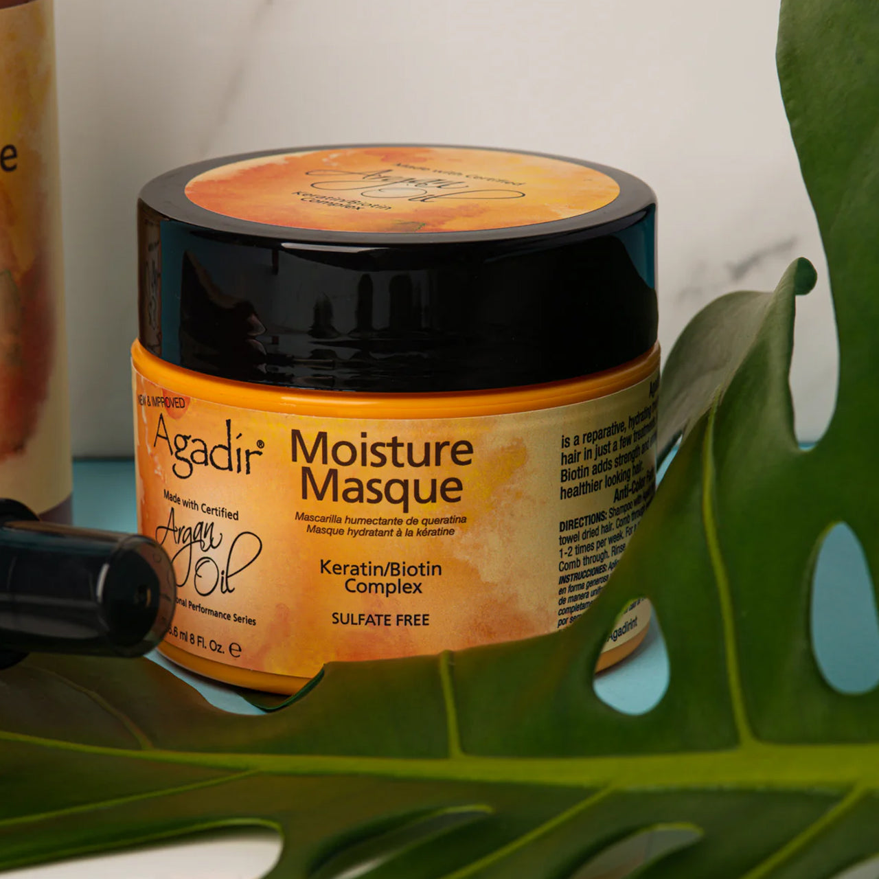 Close-up of the moisture masque being scooped from the jar, showing its creamy texture.