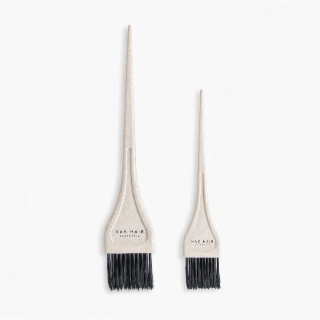 Two beige hair dye applicator brushes with black bristles, one large and one small, both branded 'NAK HAIR AUSTRALIA' on the handles, set against a plain white background.