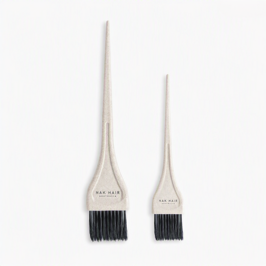 Two beige hair dye applicator brushes with black bristles, one large and one small, both branded 'NAK HAIR AUSTRALIA' on the handles, set against a plain white background.