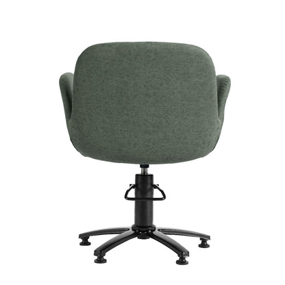 A modern upholstered salon chair with a rounded, high-back seat in textured sage green fabric, featuring integrated armrests, a black gas-lift swivel base, and five black caster wheels, shown against a plain white background.