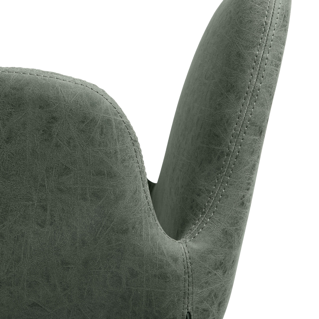 Close-up of a textured sage green upholstered salon chair back and armrest against a white background.